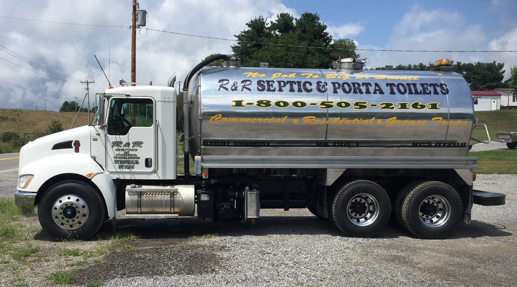 A white and silver truck labeled R&R Septic & Porta Toilets parked on gravel, featuring a large, shiny tank with yellow and black text providing a phone number and services for septic and porta potty solutions. In the background, there are patches of grass, a few trees, and a cloudy sky.
